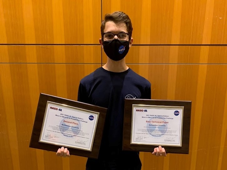 Ethan holding awards for Best Technical Paper and 2nd Overall at the 2021 NASA Mars Ice Challenge.